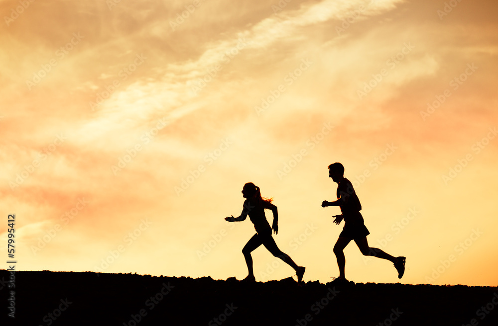 Man and woman runing together into sunset