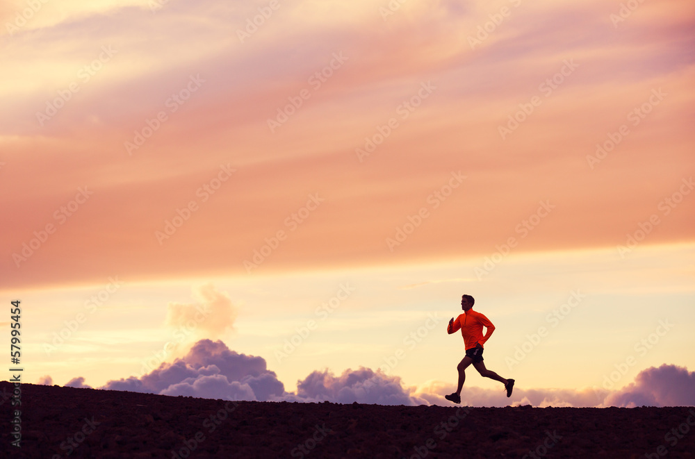 Male runner silhouette, running into sunset