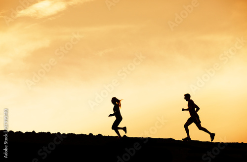 Man and woman runing together into sunset