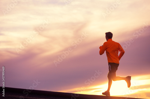 Male runner silhouette  running into sunset