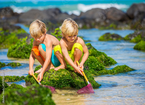 Two young boys having fun on tropcial beach photo