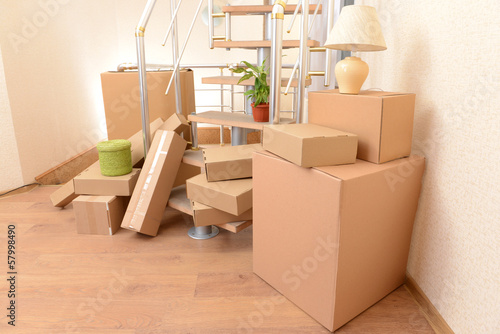 Stack of cartons near stairs: moving house concept © Africa Studio