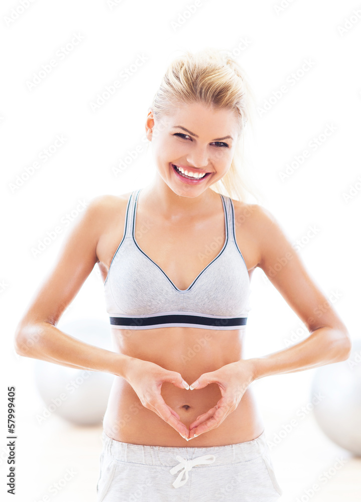 Fototapeta premium Woman making heart shape around belly button