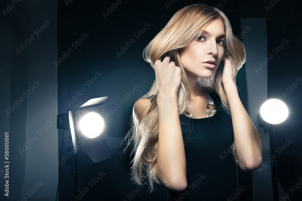 Beautiful woman posing at studio in light flashes Beautiful woman posing at studio in light flashes