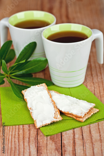 two cups of tea and crackers with cream cheese