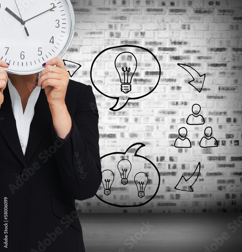 Composite image of businesswoman in suit holding a clock