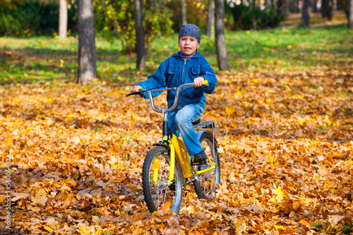 boy rides a bicycle in park