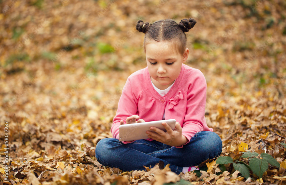 Little girl is reading from tablet Little girl is reading from tablet