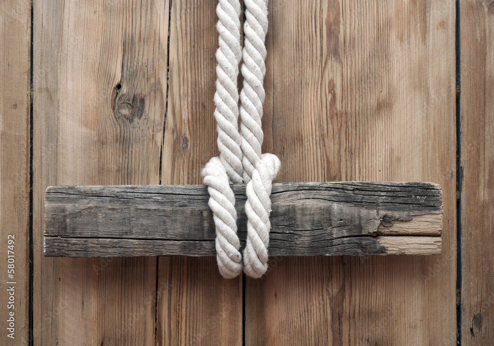 Wooden signboard with rope hanging on planks background Wooden signboard with rope hanging on planks background