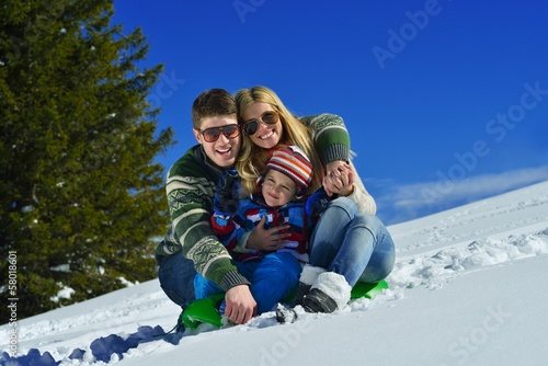 family having fun on fresh snow at winter vacation