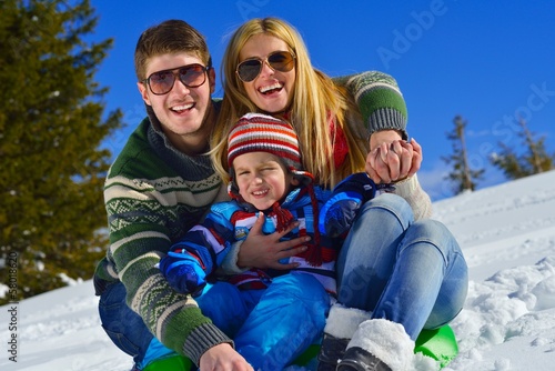 family having fun on fresh snow at winter vacation