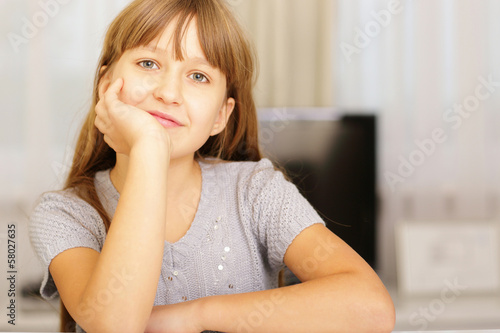 Portrait of a girl sitting at the table and looking at camera