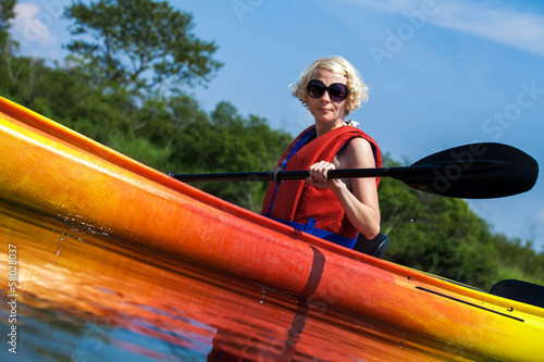 Woman With Safety Vest Kayaking Alone on a Calm River