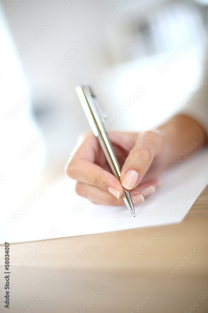 Fototapeta premium Closeup of woman's hand writing on paper