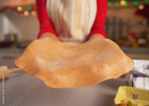 Closeup on dough in hand of young housewife