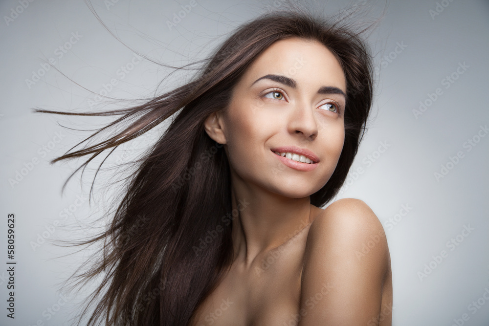 Attractive smiling woman with long hair on grey Attractive smiling woman with long hair on grey