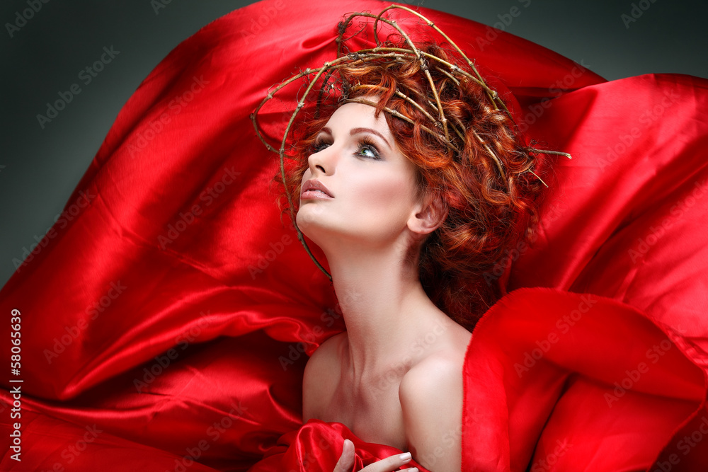 Naklejka premium Red hairs. Portrait of beautiful girl in red fabric