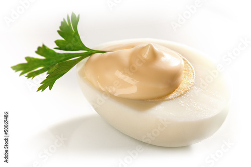 Hard boiled Egg on white background with potherb ans mayonnaise