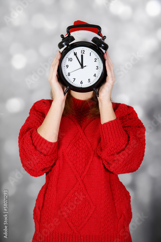Girl with big clock instead of face at light background