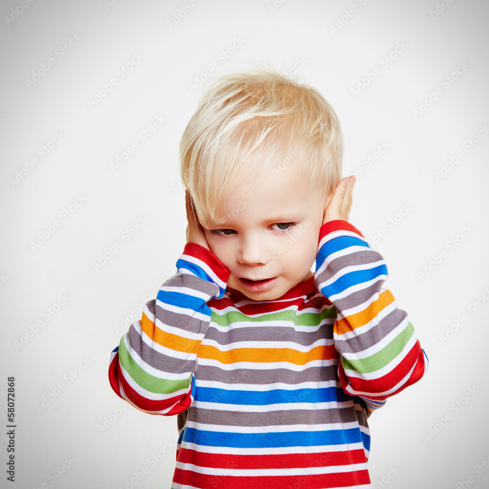 Kleines Kind hält sich die Ohren zu Kleines Kind hält sich die Ohren zu