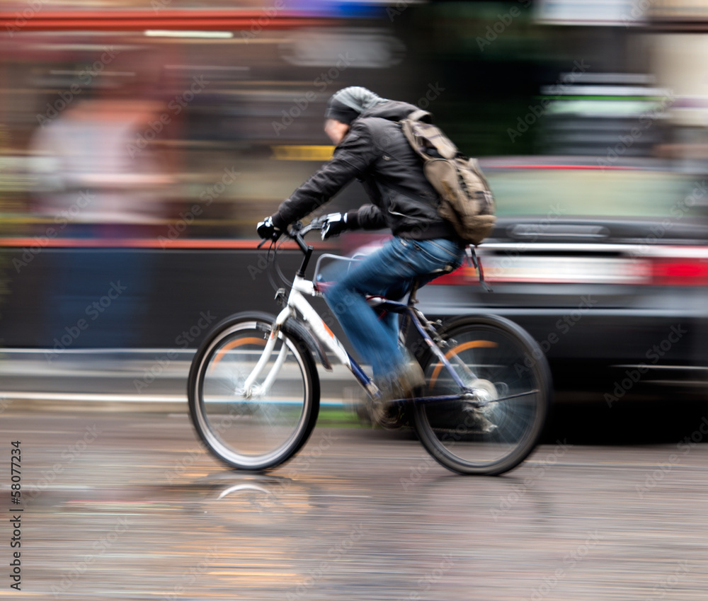 Fototapeta premium Man on bicycle in the city. Intentional motion blur