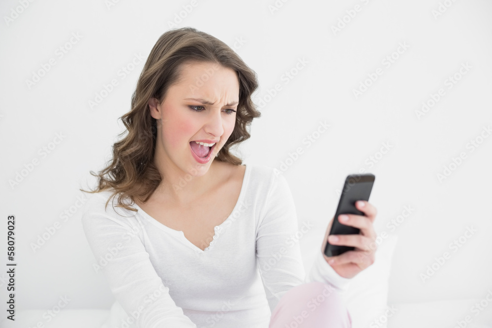 Young woman shouting into mobile phone Young woman shouting into mobile phone
