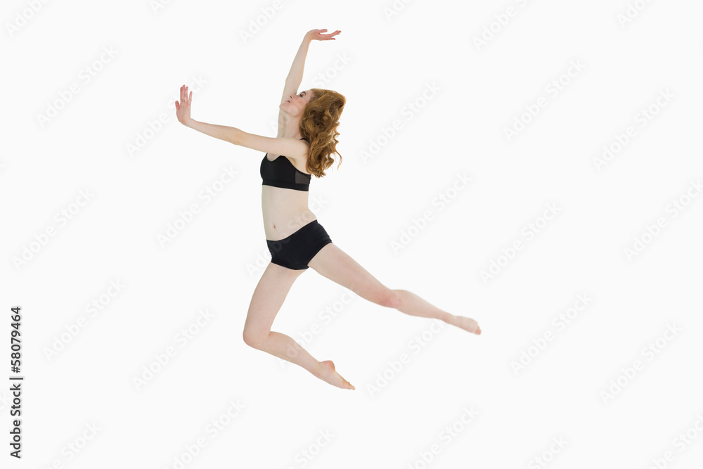 Full length side view of a sporty woman jumping