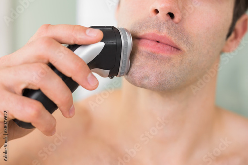Foto Extreme Close up of shirtless man shaving with electric razor