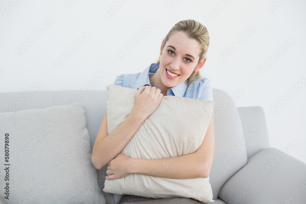 Content peaceful businesswoman sitting on couch holding a pillow Content peaceful businesswoman sitting on couch holding a pillow