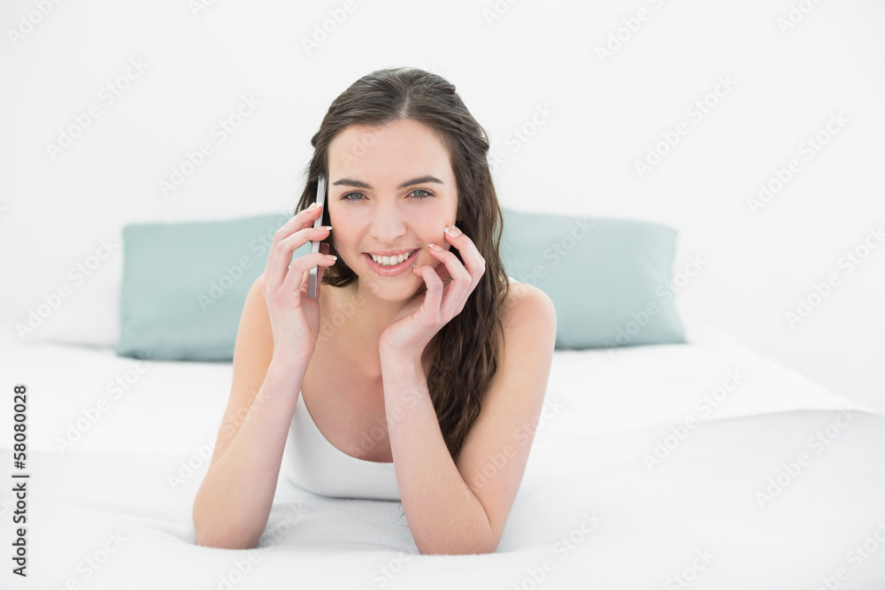 Relaxed young woman using mobile phone in bed Relaxed young woman using mobile phone in bed