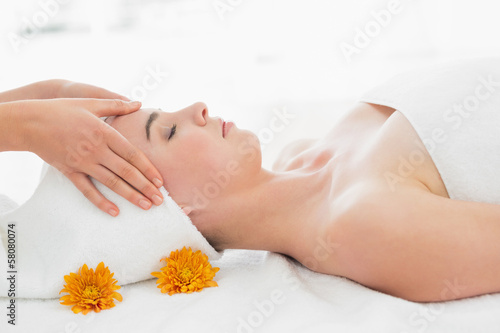 Hands massaging woman's face at beauty spa