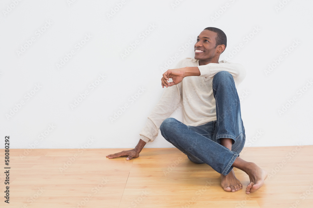 Afro man sitting on floor as he looks up to the wall Afro man sitting on floor as he looks up to the wall