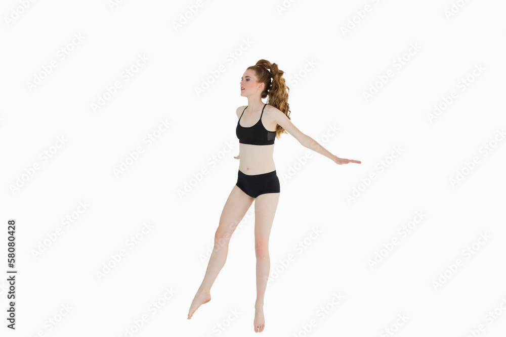 Full length of a sporty young woman stretching Full length of a sporty young woman stretching