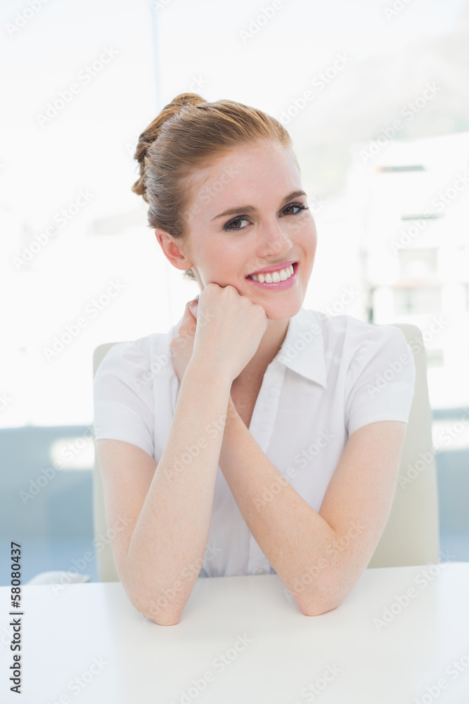 Smiling businesswoman sitting at office desk