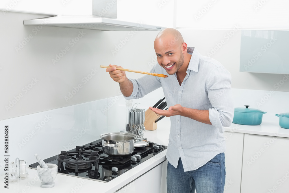 Man tasting food while preparing in kitchen Man tasting food while preparing in kitchen