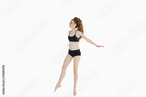 Full length of a sporty young woman stretching