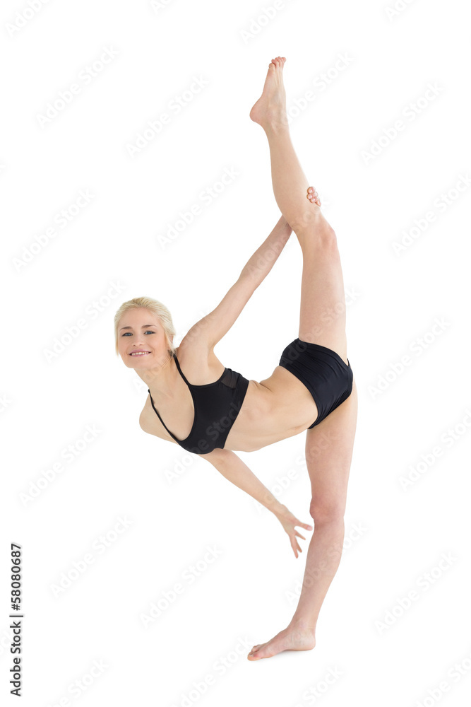 Full length of a sporty young woman stretching body