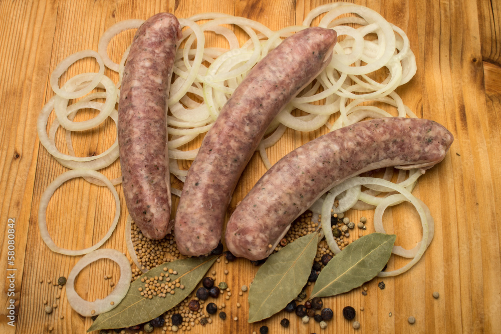 3 Bratwürste auf alter Holzplatte mit Zwiebeln 3 Bratwürste auf alter Holzplatte mit Zwiebeln