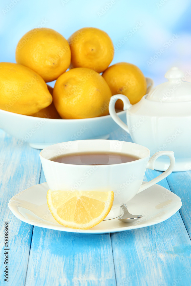 Cup of tea with lemon on table on blue background Cup of tea with lemon on table on blue background