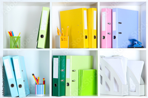 White office shelves with folders and different stationery,