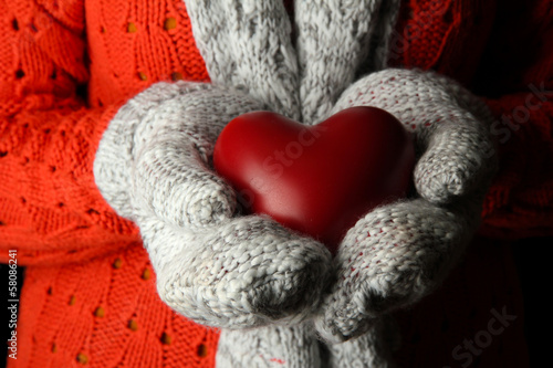 Female hands in mittens with heart  close-up