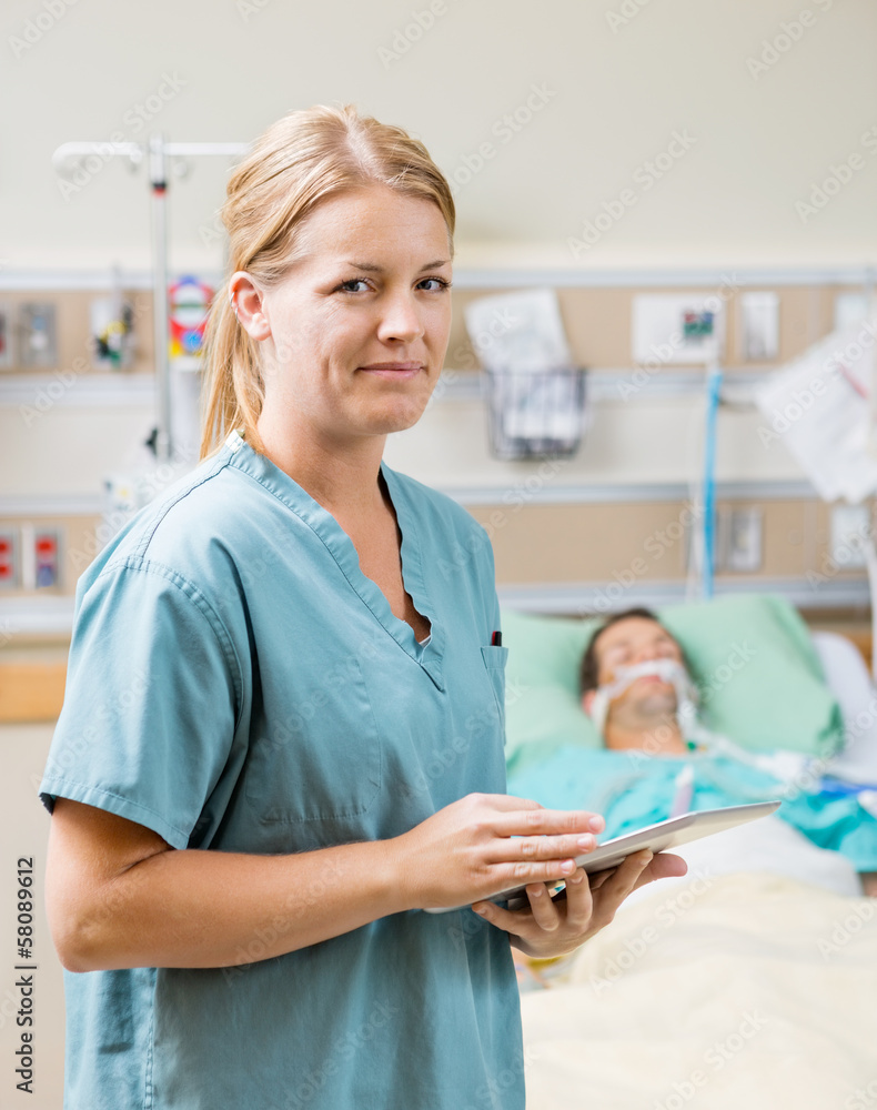 Nurse Holding Digital Tablet With Patient Resting In Hospital Nurse Holding Digital Tablet With Patient Resting In Hospital