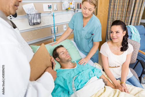 Woman Looking At Doctor While Holding Man's Hand