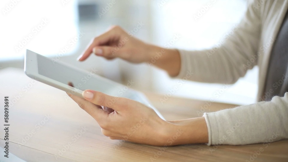 Closeup of woman's hand sliding on tablet screen Closeup of woman's hand sliding on tablet screen