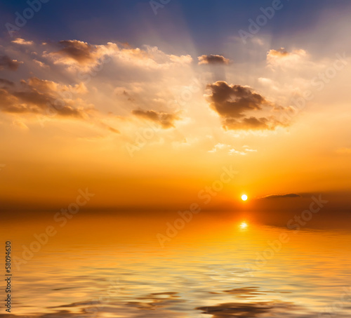 Beautiful sunset with clouds reflected in water. © Vladimir Arndt
