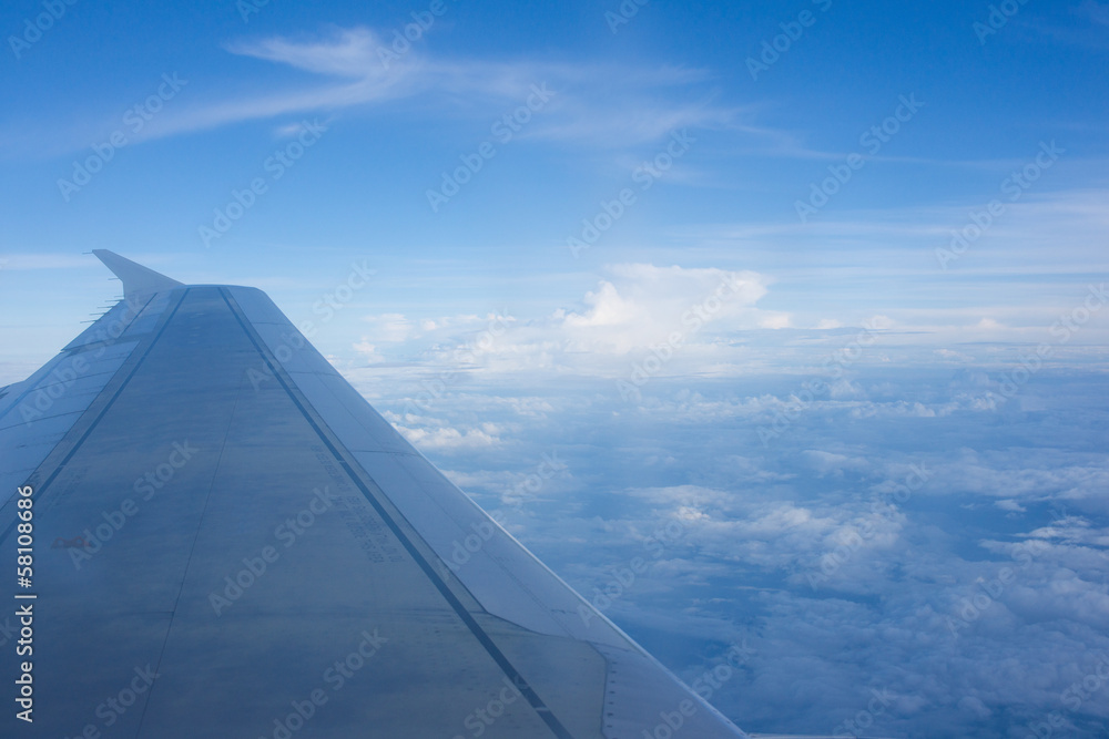 Wing of an airplane flying above the clouds