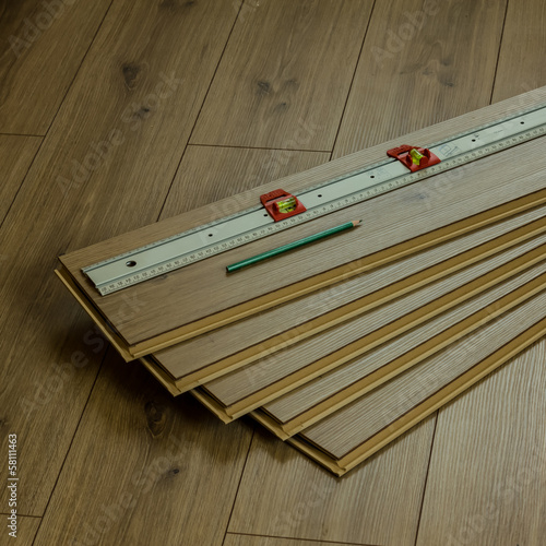 Oak laminate flooring panels with pencil and meter on top