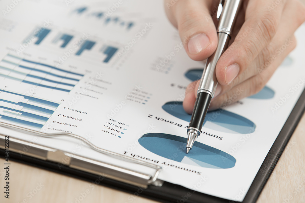 Businessman's hand showing financial report Businessman's hand showing financial report