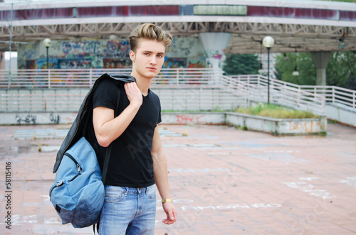 Attractive blue eyed, blond young man with ruck sack outdoors