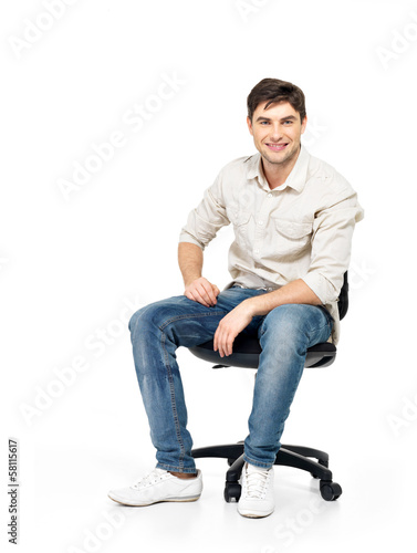 Portrait of smiling happy man sits on office chair